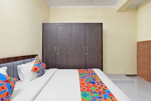 Habitación de hotel con cama, armario y una pequeña escalera.