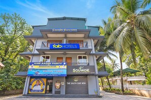 A multi-story building with a sign for 'fabHOTELS' and various other business signs.