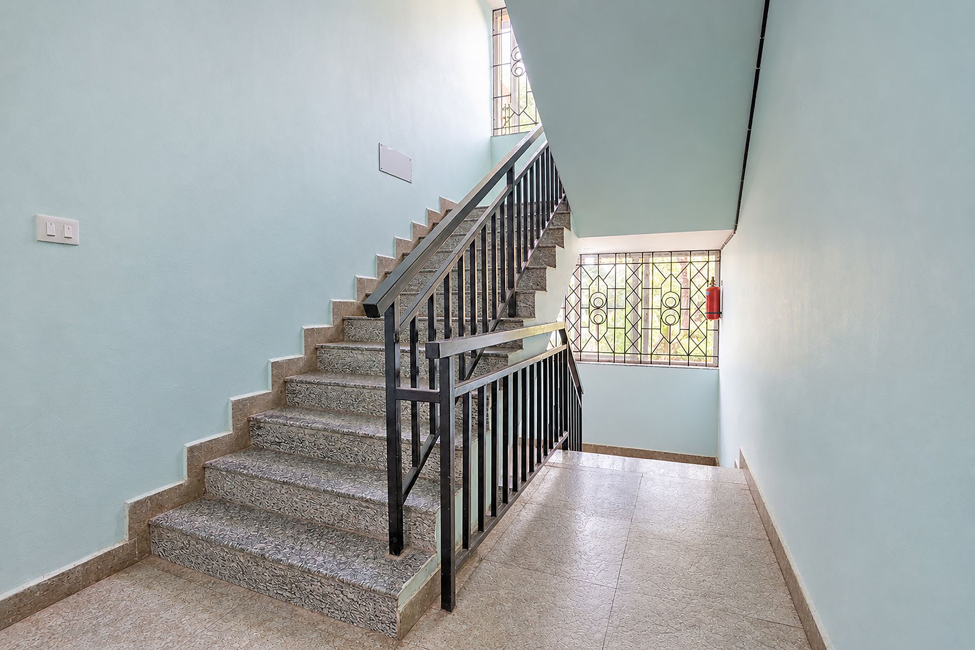 A staircase with a metal railing leading to a landing.