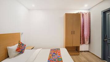 Un dormitorio con una cama, un armario de madera y una puerta con cortinas.