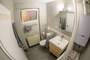 Ein kleines Badezimmer mit Toilette, Waschbecken und Spiegel.