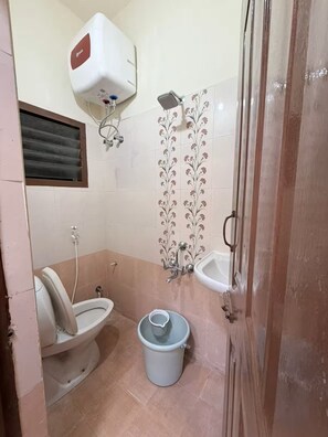 Een badkamer met toilet, bidet en douche.