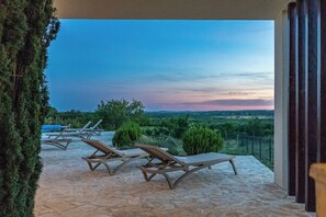A terrace with lounge chairs and a view of the landscape. - Luxury Spa Villa • Heated Pool, Jacuzzi & Sauna (Raštević)