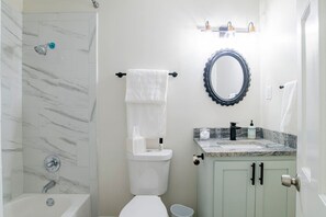 A bathroom with a shower, toilet, sink, and a mirror. - Alans Place (Mobile)