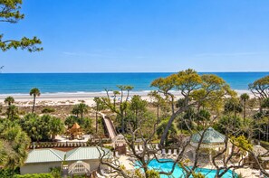 A resort with a pool, beach view, and palm trees. - 4309 Windsor Court North | Oceanfront 4BR Villa + Sweeping Ocean Views (Hilton Head Island)