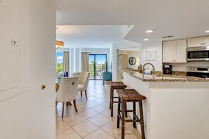 A modern kitchen with a built-in microwave, a coffee maker, and a stainless steel range hood. - 3229 Villamare | Beach Access + Incredible Resort Pools (Hilton Head Island)