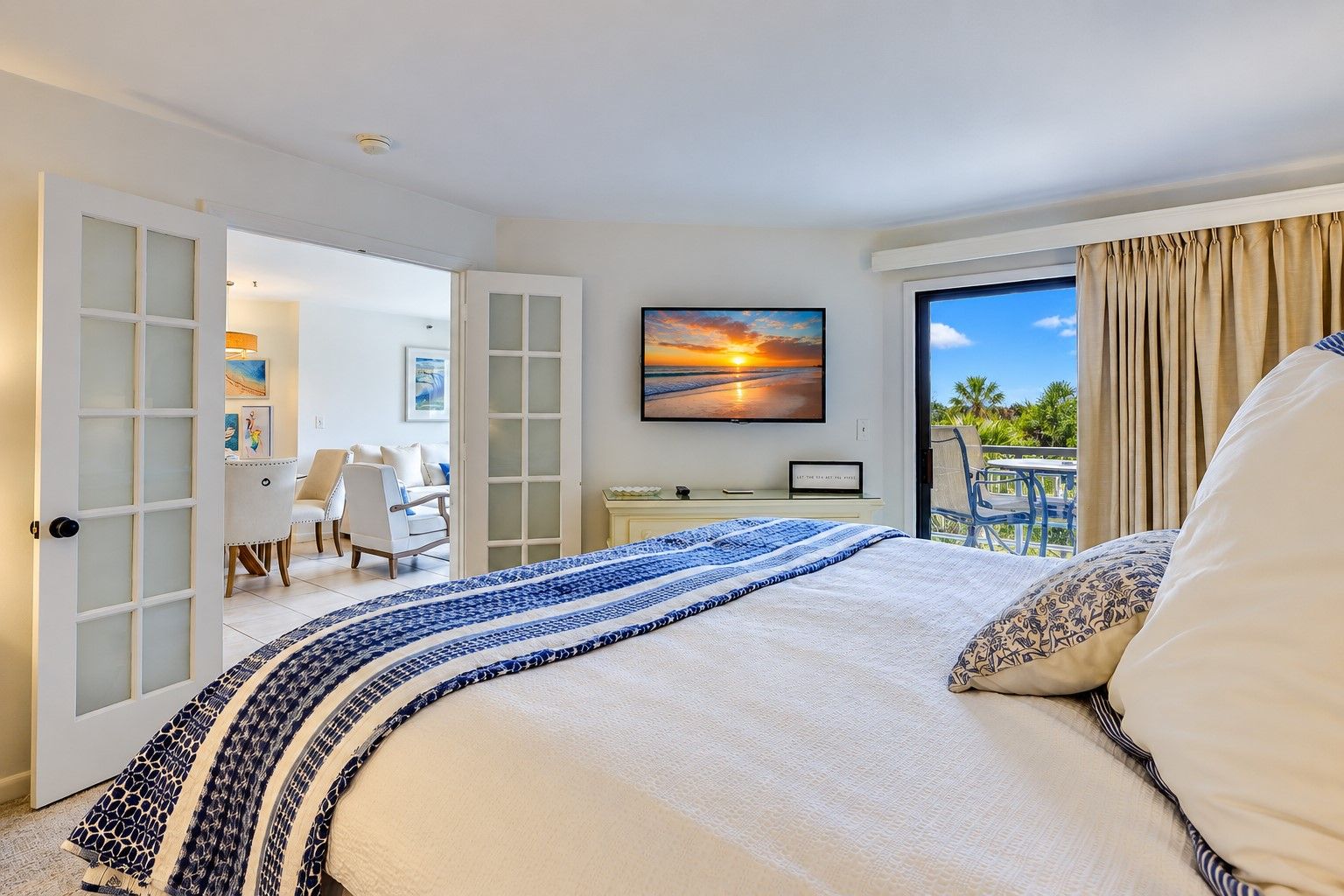 A hotel room with a bed, a desk, and a view of the outdoors.