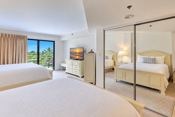 A hotel room with two beds, a television, a dresser, and a large mirror. - 3229 Villamare | Beach Access + Incredible Resort Pools (Hilton Head Island)