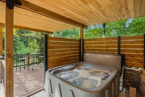 A hot tub in a wooden outdoor area with a view of trees. - The Art Loft. A piece of history nestled a mere quarter-mile from the Smoky Moun (Sevierville)