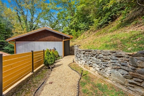 A wooden shed with a stone wall and a gravel path leading to it. - The Art Loft. A piece of history nestled a mere quarter-mile from the Smoky Moun (Sevierville)
