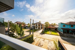 Um bairro residencial com casas, rua pavimentada e céu claro.