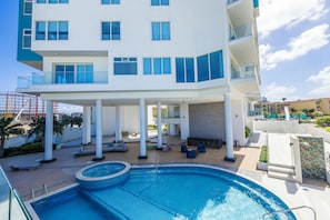 Ein modernes Hotel mit Pool, Außenbereich und einer überdachten Terrasse.