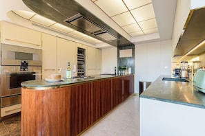 Une cuisine moderne dotée d’un îlot central, d’appareils électroménagers intégrés et d’un design épuré.