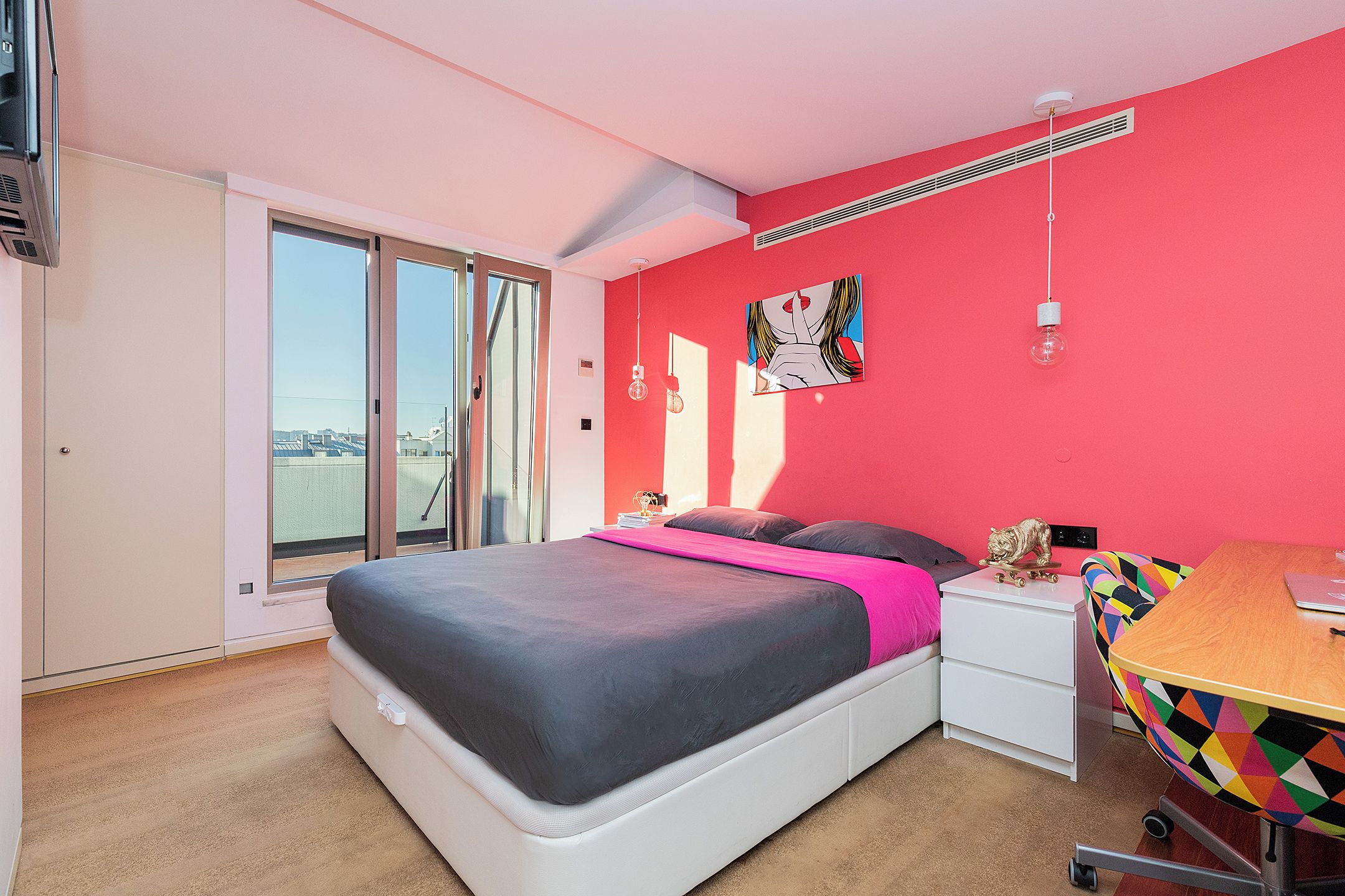 Un dormitorio con cama, escritorio, silla y ventana.
