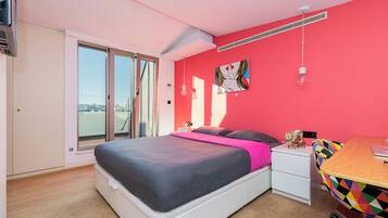 Un dormitorio con cama, escritorio, silla y ventana.
