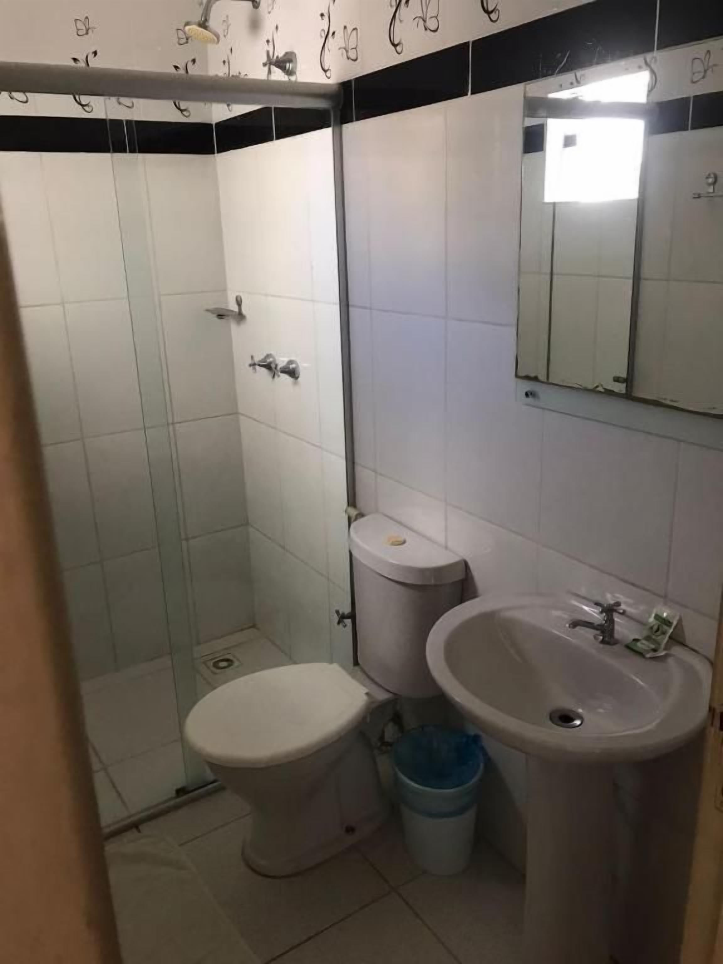 Un baño con inodoro, lavabo y ducha.