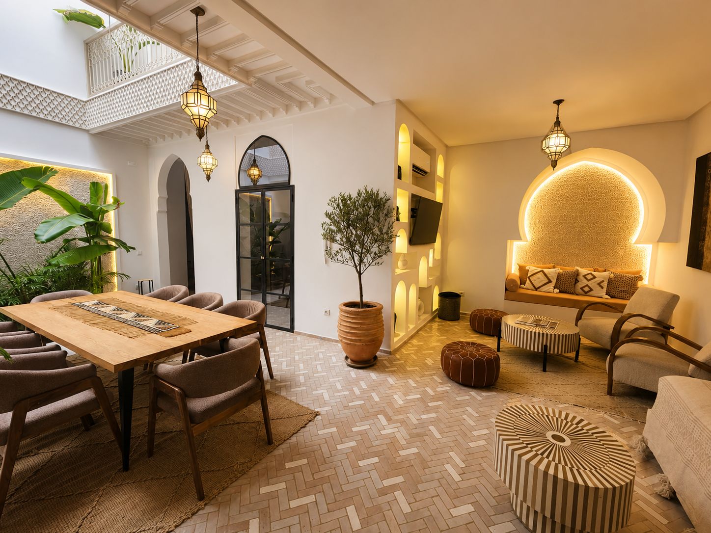Un interior moderno con zona de comedor, asientos y un muro decorativo.