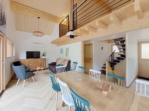 A spacious living area with a dining table, chairs, a sofa, a TV, and a staircase. - Chalet des Filles -  7/9 peoples (Saint-Jean-d´Aulps)