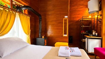 Ein Hotelzimmer mit einem Bett, einem Heizgerät, einem kleinen Tisch, einem Stuhl und einem Handtuch mit dem Hotelnamen.