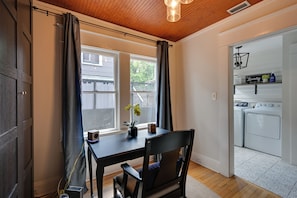 A room with a table, chair, potted plant, and a view of a laundry area. - 4BR Tampa Home, Easy Access to Dtwn (Tampa)