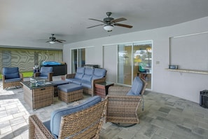 A patio area with wicker furniture, a ceiling fan, and a grill. - Canal-front Home w/ Boat Lift & Pool in Cape Coral (Cape Coral)