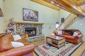 A cozy living room with a stone fireplace, leather sofas, a Christmas tree, and a staircase. - Cabin w/ Jacuzzi 1 Mi From Bear Mountain Ski (Big Bear Lake)
