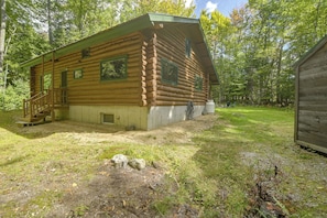 A log cabin with a porch, a small attached shed, and a grassy yard. - Maine Log Cabin! Private 2.5-acre Getaway! (Denmark)