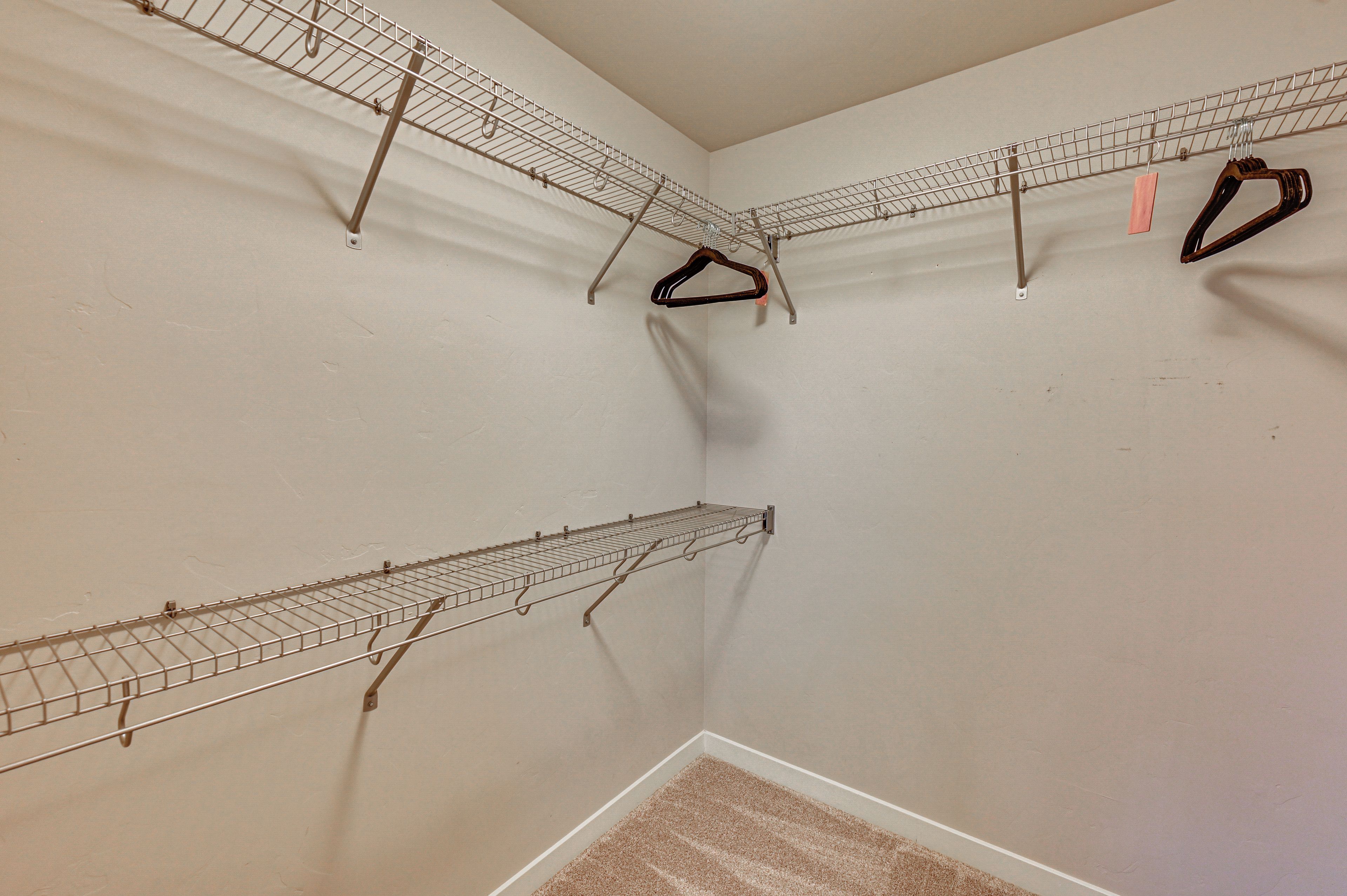 A corner room with built-in wire shelving units for storage.