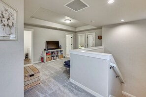 A spacious living area with a high ceiling, a television, and a bookshelf. - Family Home Close to Bend, Smith Rock & Sisters (Redmond)
