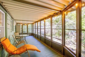A covered porch with a table and chairs, large windows, and a view of trees. - Creekside Haven 5 Mi to Dtwn Boone! Bring Your Pup (Boone)