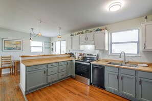 A kitchen with grey cabinets, a wooden countertop, a built-in oven, and a dishwasher. - Walk to Surfside Beach! Ocean-view Retreat w/ Yard (Freeport)