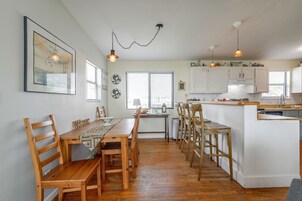 Una cocina amplia con muebles de madera, un comedor y vistas a la ciudad a través de las ventanas.