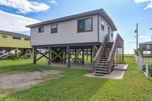 A two-story house with a wooden deck and a staircase leading to an upper level. - Walk to Surfside Beach! Ocean-view Retreat w/ Yard (Freeport)