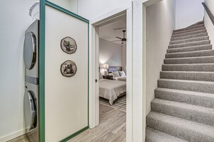A staircase leading to a bedroom with a bed and a nightstand.