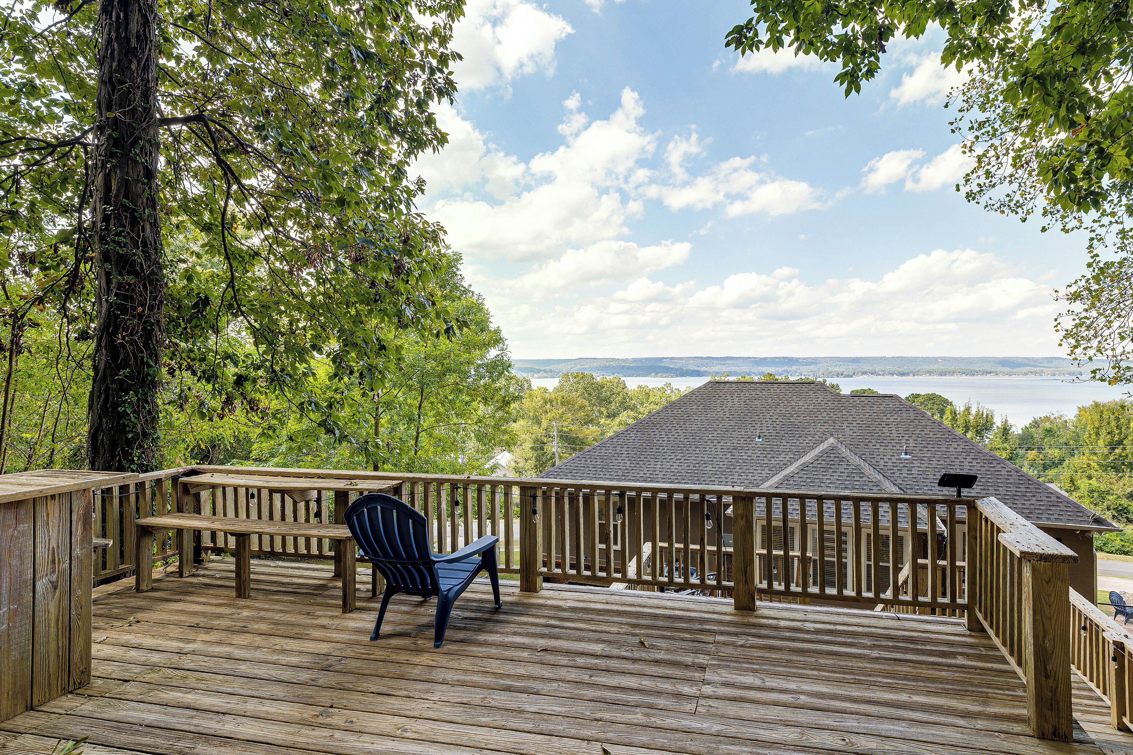 A wooden deck with a view of a body of water and distant hills.