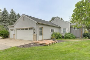 A two-story house with a garage, a front porch, and a well-maintained lawn. - New! Private Lakefront Retreat on Lindstrom Lake (Lindstrom)