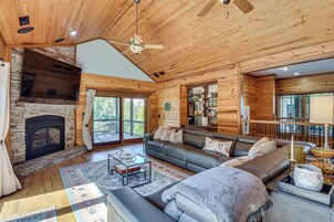 A spacious living room with a fireplace, a sofa, and a dining area.