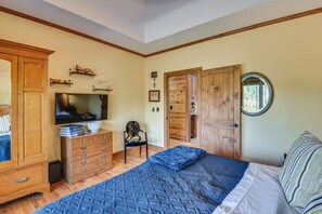 Ein Schlafzimmer mit Bett, Schminktisch, Fernseher und Holzschrank.
