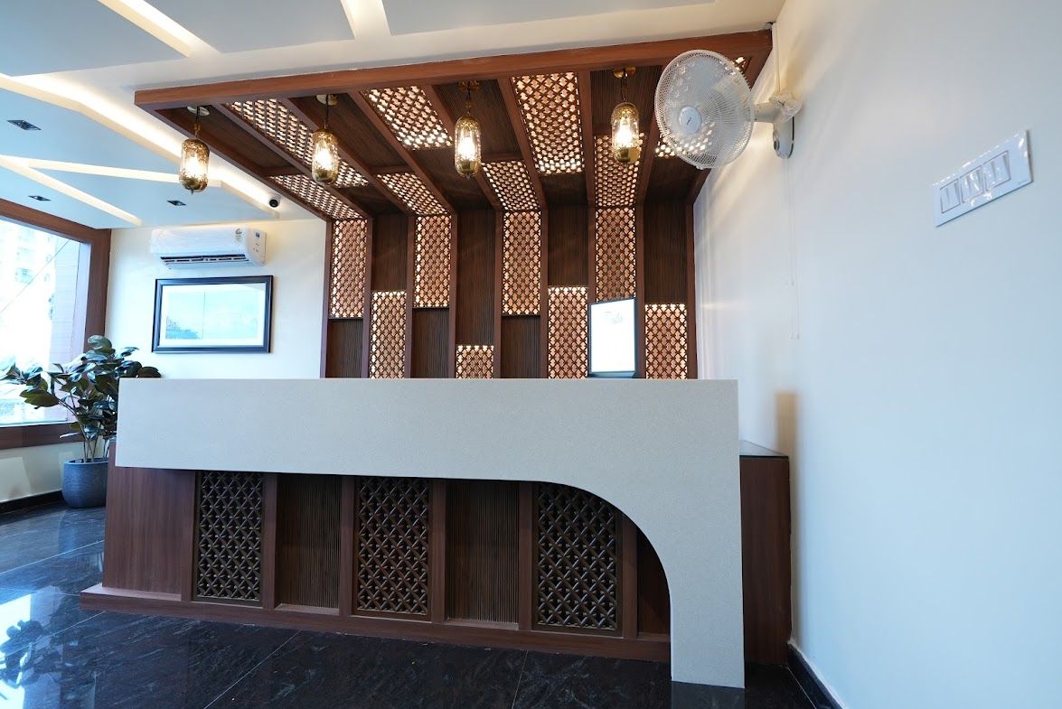 Un área de recepción con diseño moderno, que incluye un mostrador de recepción, paneles de madera decorativos y ventiladores de techo.