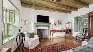 A traditional living room with a fireplace, a television, and a green-painted wall.