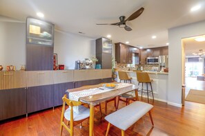 A modern kitchen with a central island, wooden flooring, and a ceiling fan. - Convenient Condo 9 Mi to Princeton University (Hightstown)