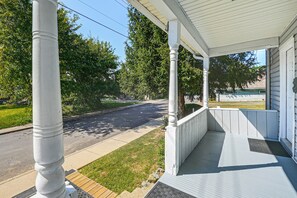 A covered porch with white columns and a wooden deck. - Modern 1br: Queen Bed, Coffee Bar & Walkin Shower (Parkersburg)
