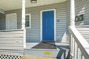 A house with a blue front door, a white porch railing, and a doormat. - Modern 1br: Queen Bed, Coffee Bar & Walkin Shower (Parkersburg)