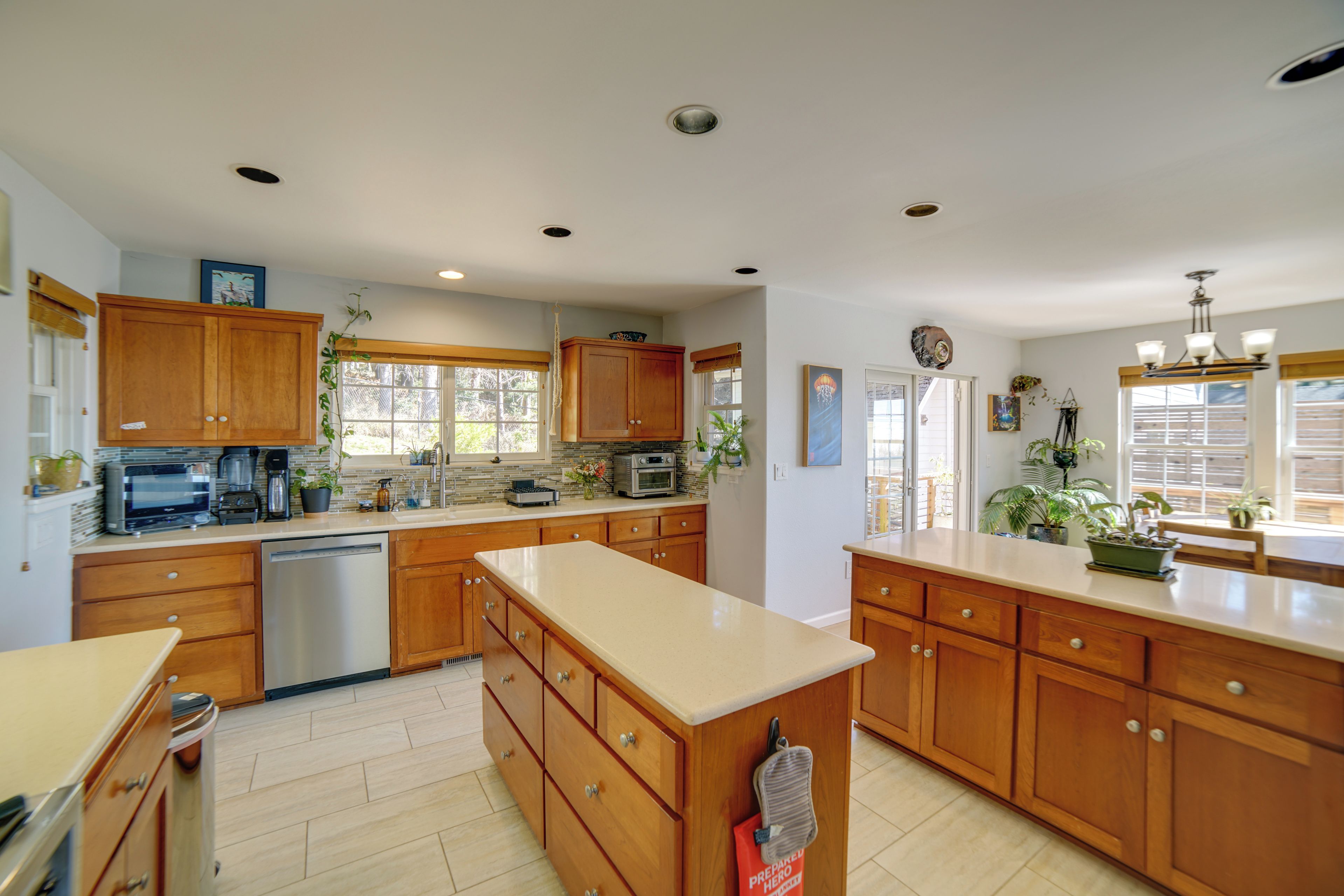 A spacious kitchen with wooden cabinets, a dishwasher, and a large island.