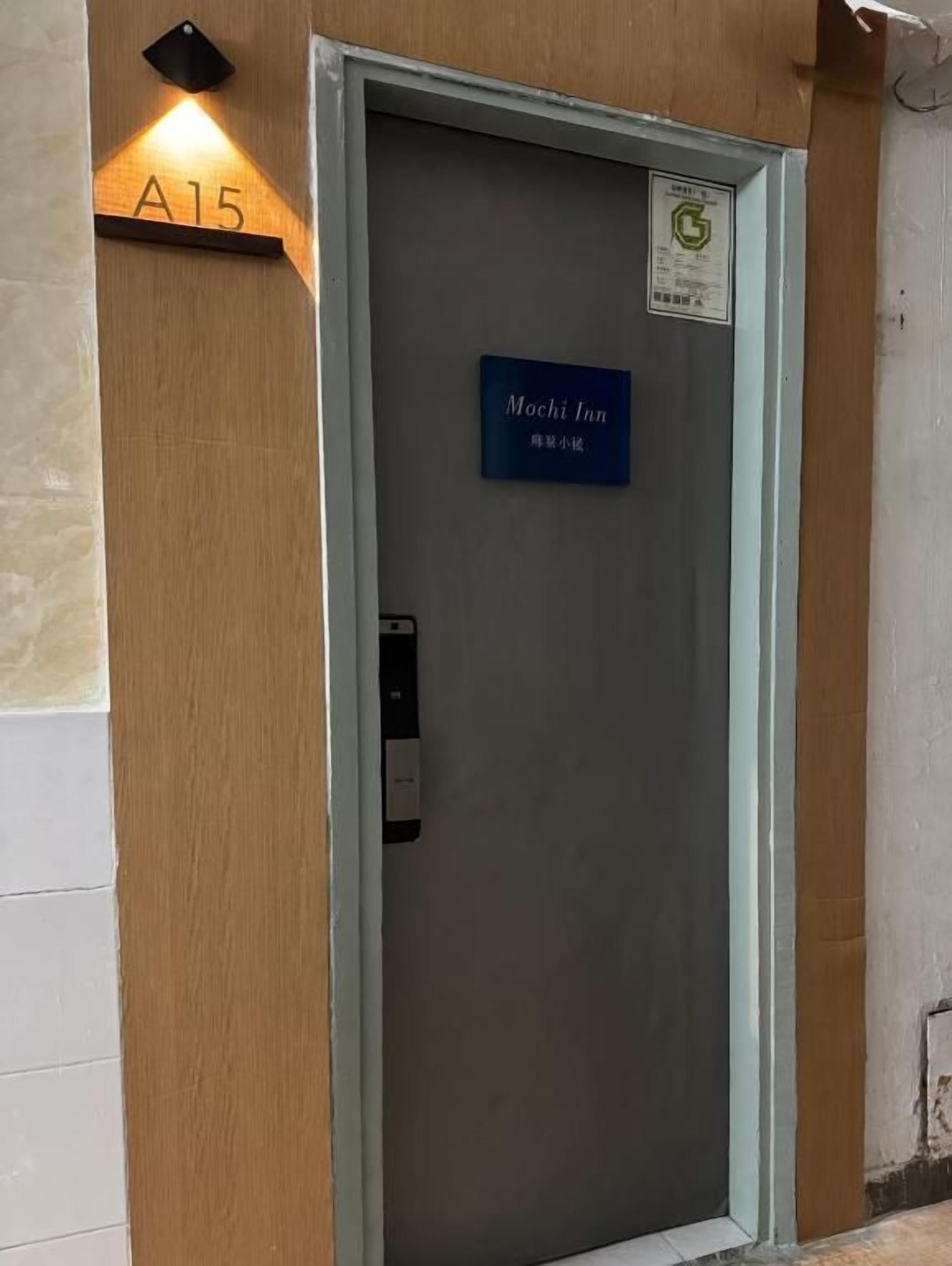 A hotel room entrance with a sign indicating 'Mochi Inn' and a doorbell.