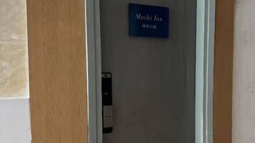A hotel room entrance with a sign indicating 'Mochi Inn' and a doorbell.