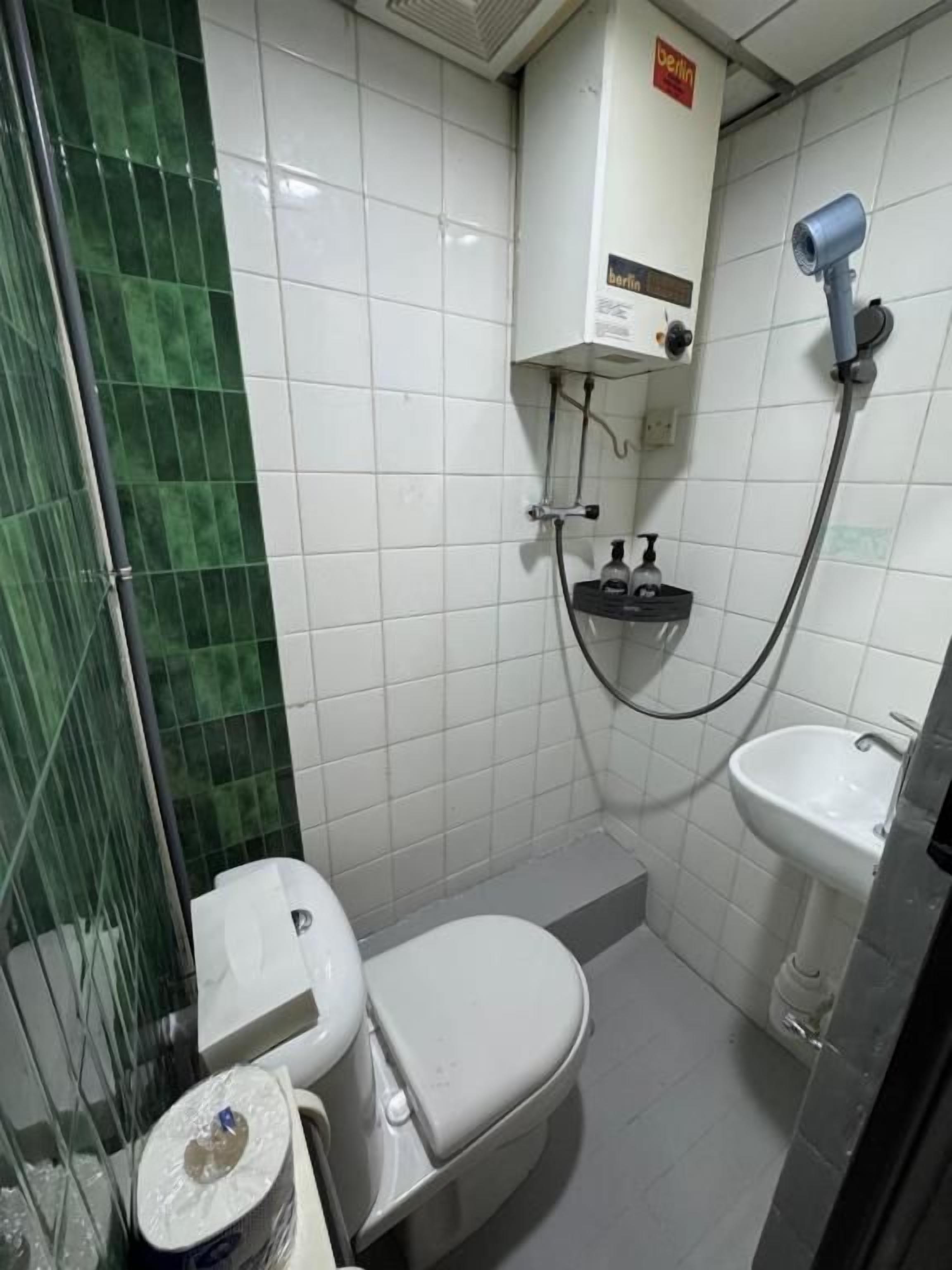 A bathroom with a toilet, sink, and shower.