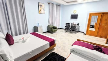 Une chambre d’hôtel avec deux lits, un bureau, une chaise, une télévision et une armoire.