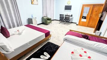 Une chambre d’hôtel avec deux lits, un bureau, une chaise, une télévision et une porte.