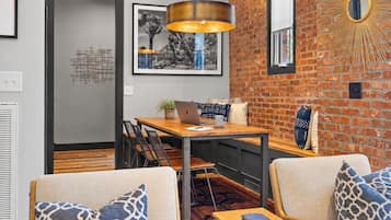 Een modern interieur met een eethoek, zitplaatsen en een metselwerk muur.